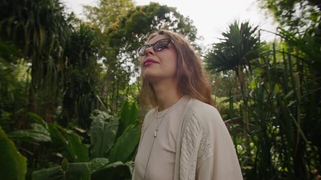 Woman enjoying a peaceful walk through lush tropical rainforest surrounded by exotic plants and breathtaking natural scenery in the wilderness