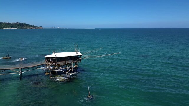 Aerial of a fishing hut facing the coastal headland 4k drone