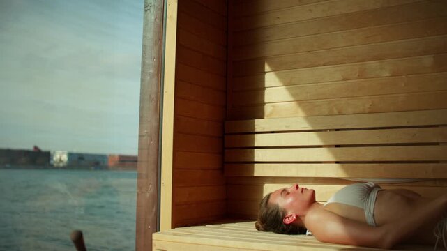 Wellness in the sauna with a woman resting by the waterfront