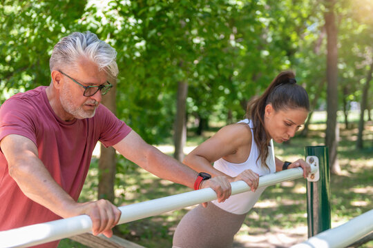 Senior man and fitness instructor performing a guided push-up workout focused on posture, upper body conditioning, shoulder stability, coordination, and healthy aging through functional exercise.