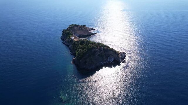 Beautiful aerial view of a sandy beach with crystal clear sea, turquoise water and visitors enjoying swimming and paddleboarding on Thassos Island, Greece.