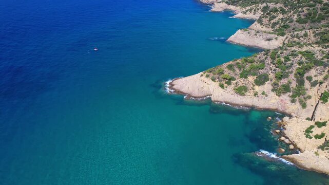 Aerial drone  of a peaceful beach in Thassos, Greece, featuring transparent turquoise water, paddleboards, swimmers and a beautiful Mediterranean coastline.