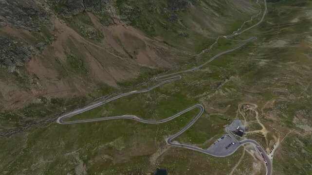 Scenic aerial view of the Timmelsjoch High Alpine Road with a tourist vehicle driving across breathtaking alpine mountains in Austria for European travel