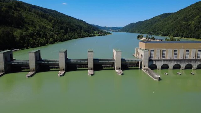 Aerial orbit of the weir gates and powerhouse at the Jochenstein hydropower plant on the Danube