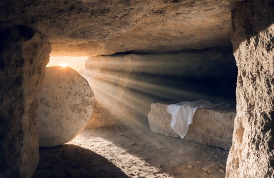 Bright morning sunlight rays shining into empty stone tomb cave with folded linen clothes on slab for traditional christian happy easter resurrection holiday religious celebration background.