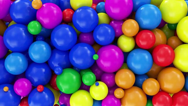 Colorful glossy balls bounce and pile up against a light background, filling the frame with bright playful motion in a clean abstract 3D animation
