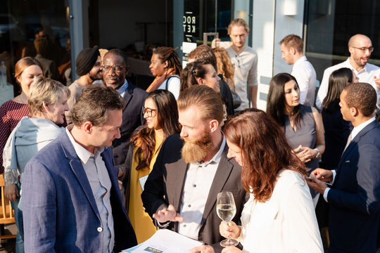 Diverse group of people networking at an outdoor social event.