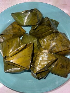 Traditional Malaysian leaf-wrapped rice dumplings neatly arranged on a plate, showcasing authentic homemade cuisine and cultural heritage.
