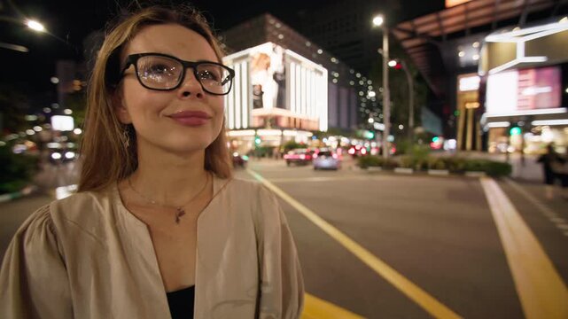 Woman admiring the night cityscape of Singapore City with glowing streets contemporary architecture and vibrant urban atmosphere during travel in Asia