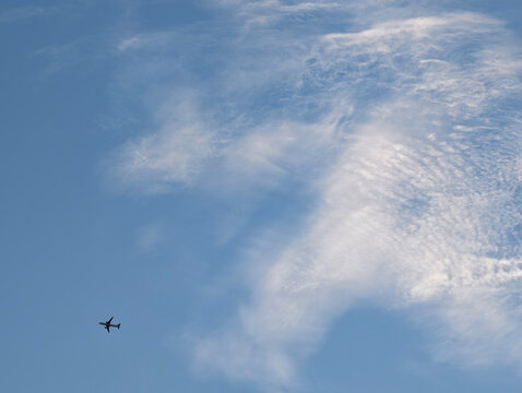 Aircraft flying through dramatic sunset clouds 