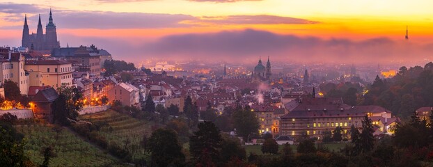Obraz premium The cityscape of UNESCO city site of Prague and Hradcany castle in autumn morning dawn in mist.