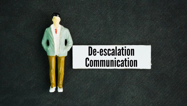 Miniature people with word De-escalation communication is a set of verbal and non-verbal techniques used to reduce tension, calm an agitated person, and prevent a conflict from turning dangerous or vi