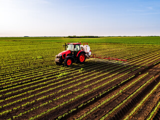 Red tractor spraying soybean field aerial crop protection © oticki