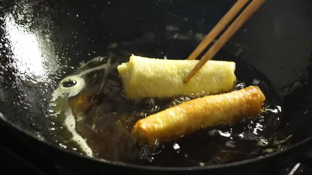 Deep Frying Golden Spring Rolls in Hot Oil Wok Close Up