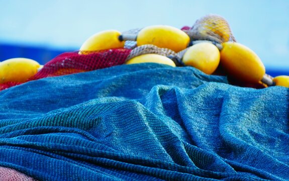 Fishing nets on the boat by the blue sea in Mediterranean city, nautical equipment background