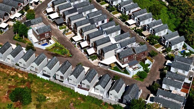 Aerial view of modern residential housing complex with uniform houses and paved roads in a tropical setting in Bali, Indonesia.