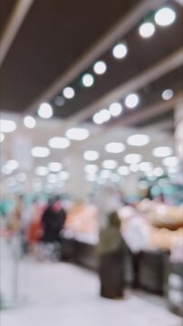 A blurred supermarket interior, glowing bokeh ceiling lights, and shoppers in motion.