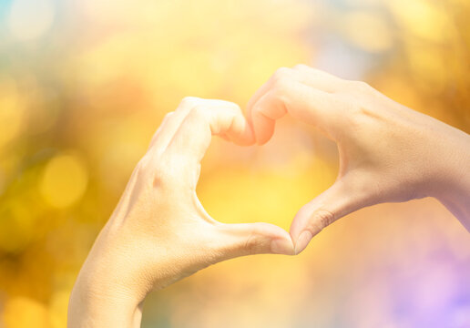 Hands in heart shape framing on nature background