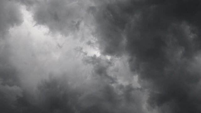 Swirling dark thunderstorm clouds with light breaking through center