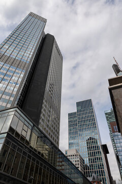 FRANKFURT, GERMANY - APRIL 4, 2026: A vertical low-angle view of the modern Trianon and Omniturm skyscrapers rising into a cloudy sky in the banking district