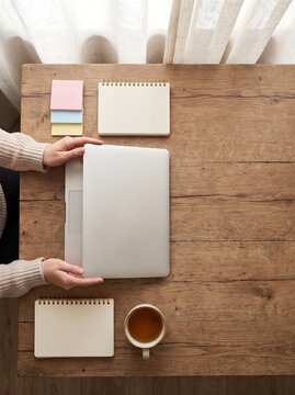 Top View Hands Opening Laptop on Wooden Desk with School Supplies
