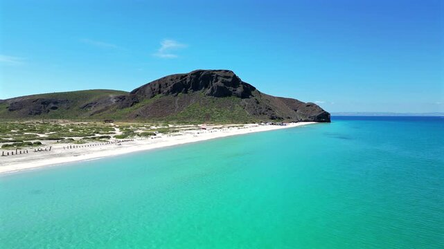 Drone pushes in from the water toward Punta Shiro at El Tecolote Beach near La Paz, approaching the point along that section of shoreline.