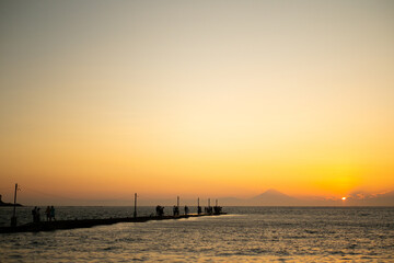 Fototapeta premium 夕焼けに染まる海と桟橋の風景