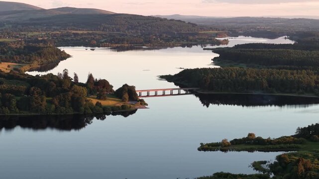 Beautiful drone view of Blessington Lakes at blue hour with peaceful islands and bridge, Ireland