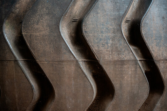 Heavy machinery tire tread texture showing worn industrial rubber surface.