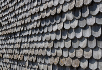 background of wooden grey shingles in harmonic structure at a farm house in grazing light © travelview