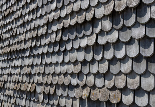 background of wooden grey shingles in harmonic structure at a farm house in grazing light