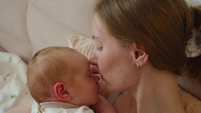 Mother kisses infant nose during close, playful exchange. Small gesture adds humor and tenderness without interrupting calm contact, helping affection feel immediate, personal, and warm.