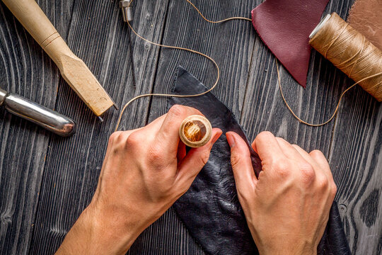 work in leather shop on dark wooden background top view