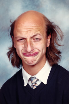 people of ai, yearbook photography of a person with bald crown with long brown side hair, exaggerated sly grin, wearing navy sweater, 1980s portrait black, photorealistic DOC