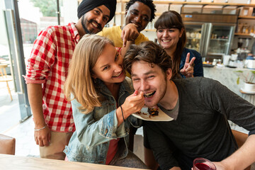 Obraz premium Group of friends enjoying dessert together in a cafe setting.