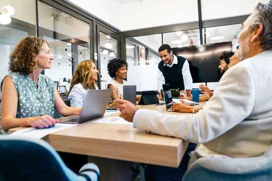 Business professionals discussing work in a corporate environment. Colleagues interacting and planning during a team meeting