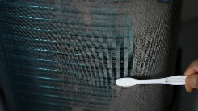 Close-up of a hand using a cotton swab to clean or test a dark textured surface with blue streaks, Hand using cotton swab on textured surface