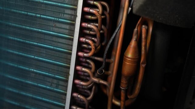 Close-up of air conditioner or refrigerator cooling parts with copper pipes and metal fins, Close-up of cooling system copper pipes and fins