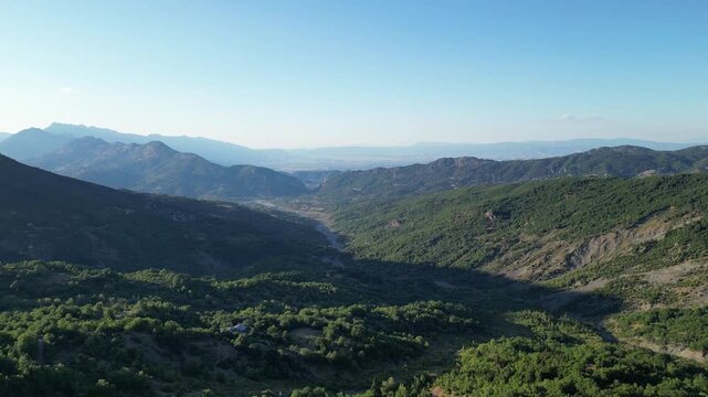 Panoramic aerial view of deep green mountain valley stretching towards distant horizon in Pindus range Thessaly Greece for outdoor nature travel video background. High quality 4k footage