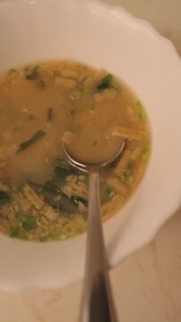 Serving hot seafood soup with spoon