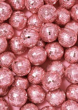 A close-up overhead view of a pile of many small, sparkling, pink disco balls