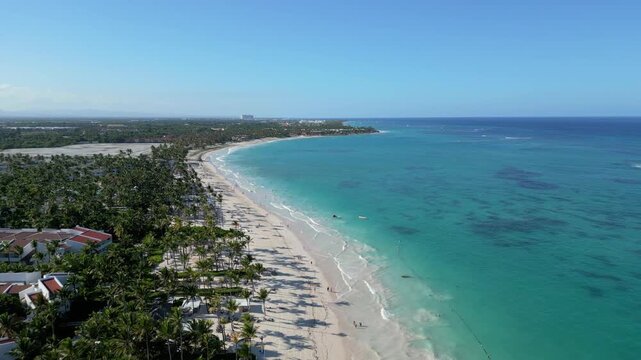 Vista a&eacute;rea movi&eacute;ndose hacia adelante de una playa tropical en Punta Cana, Rep&uacute;blica Dominicana, con agua turquesa en un d&iacute;a soleado de verano