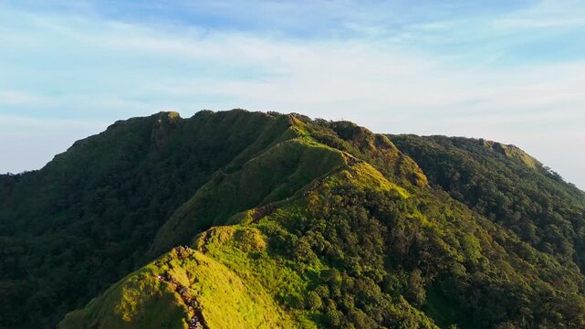 Aerial view of the lush green ridge and forest slopes of Mount Ungaran in Ungaran Barat, Central Java, Indonesia.
