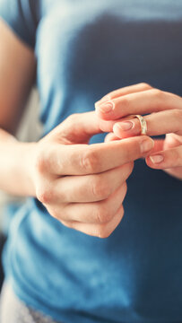 Woman takes off an wedding ring