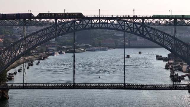 Aerial view of the iconic Luis I Bridge with a train crossing the upper deck over the Douro River in Porto, Porto District, Portugal.