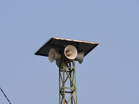 Mosque Loudspeaker Mounted on Tower Against Blue Sky