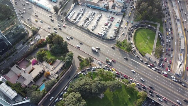 Aerial view of heavy traffic on Avenida Javier Prado Este with surrounding urban buildings, parking lots, and green spaces in San Isidro, Lima Province, Peru.
