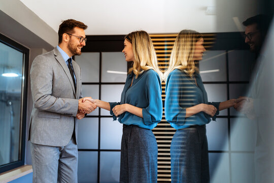 Portrait of successful business people working, talking together in corporate office during work.