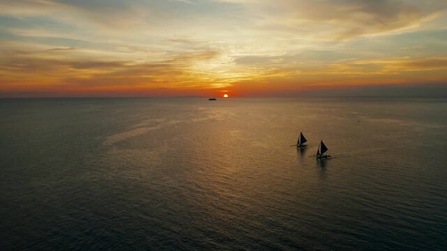 Sailing boat silhouette during sunset, aerial view Boracay, Philippines. Reflected sun on a water surface. Sunset over ocean. Seascape, Summer and travel vacation concept