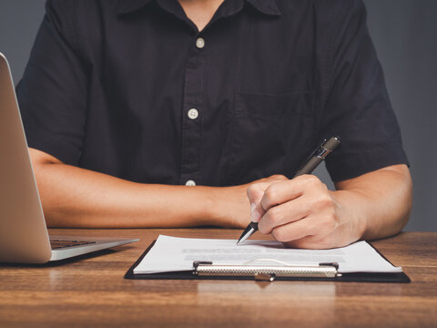 Signing Paper Document on Clipboard